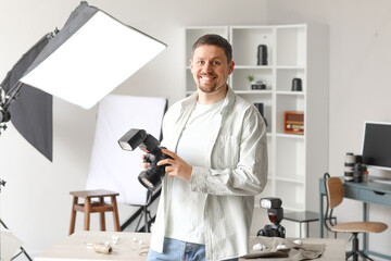 Handsome photographer with professional camera in studio