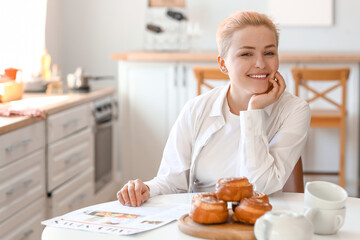 Young woman sitting at table in kitchen