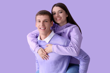 Happy young couple on lilac background