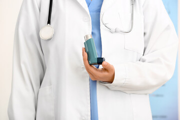 Female doctor with inhaler in office