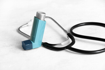 Asthma inhaler with stethoscope on table in doctor office
