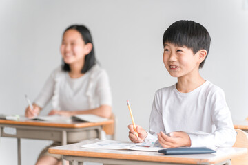 学校の教室で勉強する小学生の男の子（塾・夏期講習）
