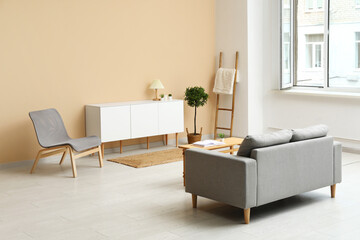 Modern living room interior with cozy grey sofa, cabinet and table