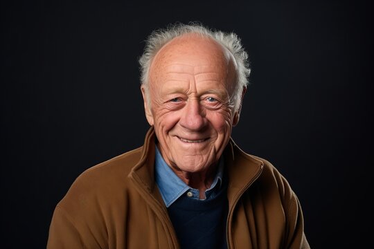 Portrait of a happy senior man looking at the camera on a black background