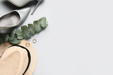Composition with stylish female accessories, shoes and eucalyptus branch on light background © Pixel-Shot