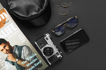 Composition with stylish female accessories, magazine and gadgets on dark background