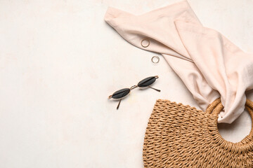 Stylish female bag, sunglasses and rings on light background