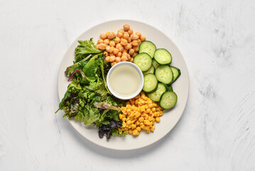 Plate with fresh vegetable salad on light background