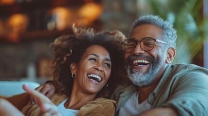 Various couples watch TV Pointing and laughing in a sunny living room.