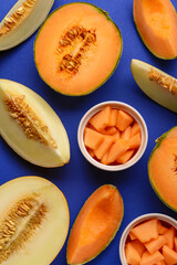 Sweet melons and bowls of pieces on blue background