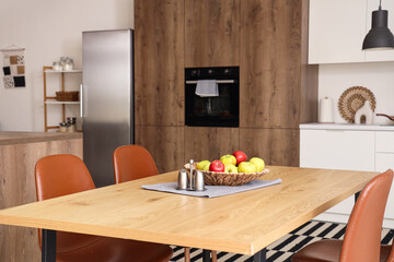 Plate with apples on dining table in kitchen