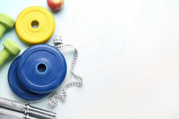 Barbell plates, measuring tape and dumbbells on white background