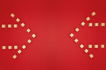 Fototapeta na wymiar 左右から対称的な2つのウッドキューブの矢印のフレームが中心を指す赤い背景