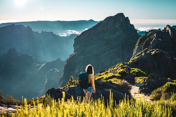 Female tourist walks down a panoramic hiking trail and overlooks the breathtaking depths of a...