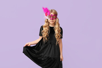 Pretty little girl wearing carnival mask on lilac background