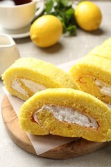 Delicious cake roll with cream filling on grey table, closeup