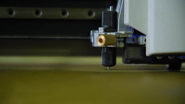 Commercial plotter is cutting a paper. Close up shot