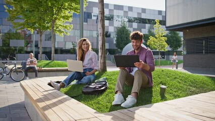 Freelancer team working park together. Smiling couple browsing laptop computer - Powered by Adobe