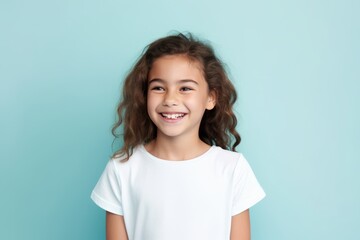 Portrait of a cute little girl in a white T-shirt on a blue background