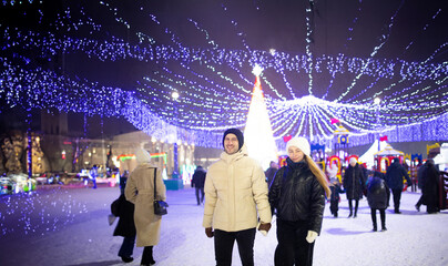 couple in love at the city fair in winter clothes and hats in winter in the city for Christmas​	