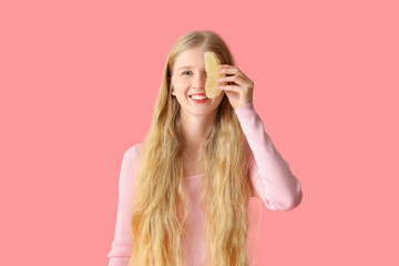 Young woman with pomelo slice on pink background