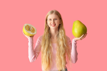 Young woman with pomelo on pink background