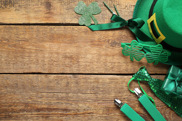 Leprechaun hat with suspenders, plastic eyeglasses and decor on wooden background. St. Patrick's...