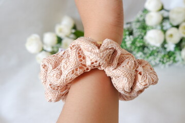 A cream scrunchie that is in the shape of a circle
