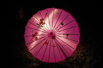 ライトアップされて輝くピンクの和傘