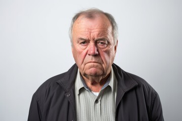 Senior man making funny face on grey background. Portrait of senior man.