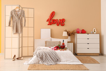 Interior of festive bedroom with wine on bed and decorations for Valentine's Day celebration