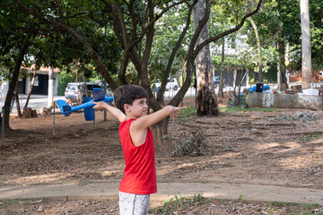 10 year old Brazilian child playing with his Styrofoam plane on a sunny afternoon_2.