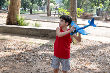 10 year old Brazilian child playing with his Styrofoam plane on a sunny afternoon_3.