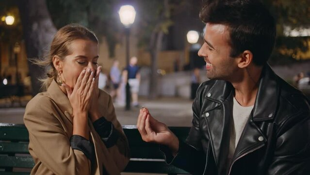 Happy man giving ring making proposal in night park closeup. Excited girl hug