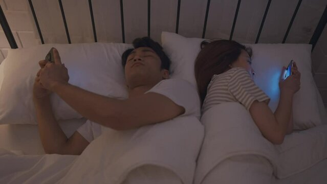 Asian young phone addict couple don't pay attention with each other. 