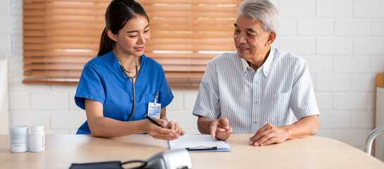 Asian young caregiver nurse examine senior older man patient at home. 