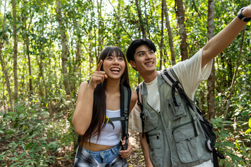 Asian two young backpacker vlogger have fun travel in forest together. 