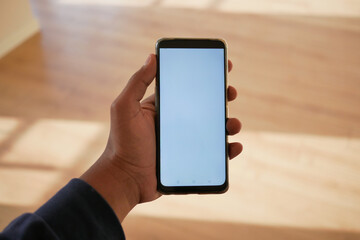 pov shot of hand using phone showing empty screen in empty room