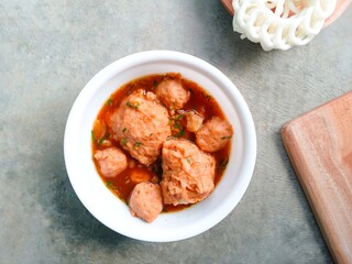 bakso, meatballs, traditional Indonesian food. Meatball soup with crackers. meatballs stuffed with quail eggs without noodles or vermicelli served in a bowl on a gray background. Top view