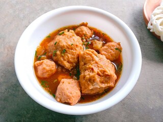 bakso, meatballs, traditional Indonesian food. Meatball soup with crackers. meatballs stuffed with quail eggs without noodles or vermicelli served in a bowl on a gray background.