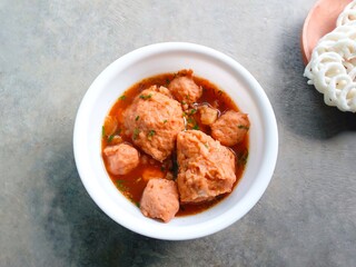 bakso, meatballs, traditional Indonesian food. Meatball soup with crackers. meatballs stuffed with quail eggs without noodles or vermicelli served in a bowl on a gray background.