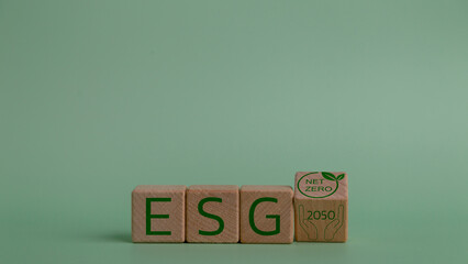 Wooden blocks with the word ESG on a green background. Net zero by 2050. Carbon neutral. Net zero...