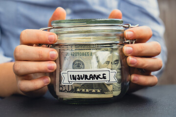 Unrecognizable woman holding Saving Money In Glass Jar filled with Dollars banknotes. INSURANCE...