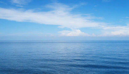 Fototapeta premium Tranquil Seascape under a Clear Blue Sky with Fluffy Clouds on a Sunny Summer Day