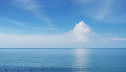 Obraz premium Tranquil Seascape under a Clear Blue Sky with Fluffy Clouds on a Sunny Summer Day