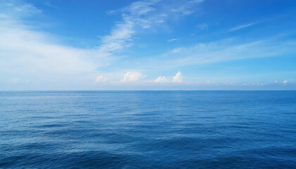 Obraz premium Tranquil Seascape under a Clear Blue Sky with Fluffy Clouds on a Sunny Summer Day