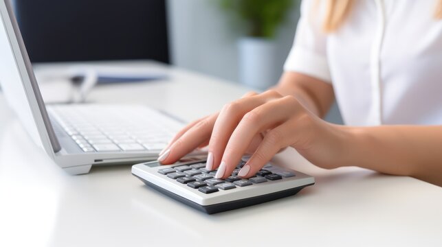 A Businesswoman's hands using a calculator, white isolated background.