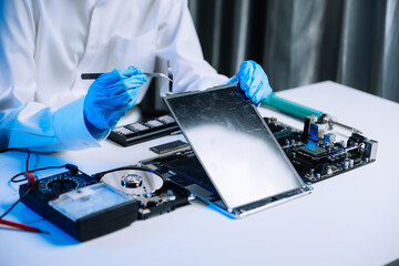Obraz premium Hard disk drive on the technician's desk and a computer motherboard as a component. the concept of data, hardware, and information technology.