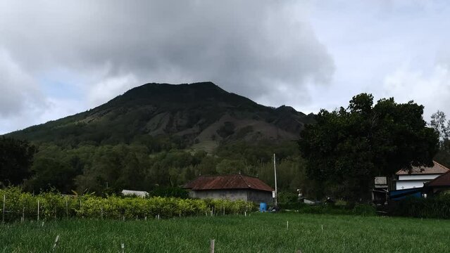 timelapse video of hills, onion plantations, chili plantations and residential houses with cloud movement