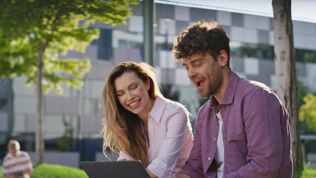 Colleagues giving high five working in park closeup. Happy team working laptop